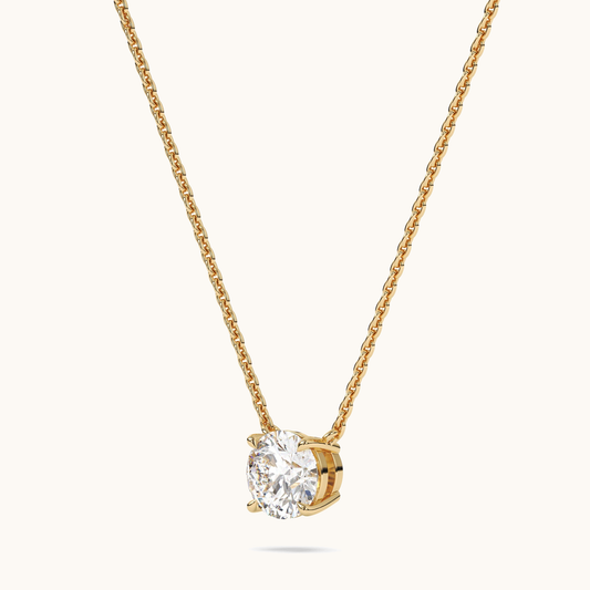 Round brilliant lab-grown diamond pendant on a yellow-gold chain, three-quarter side view