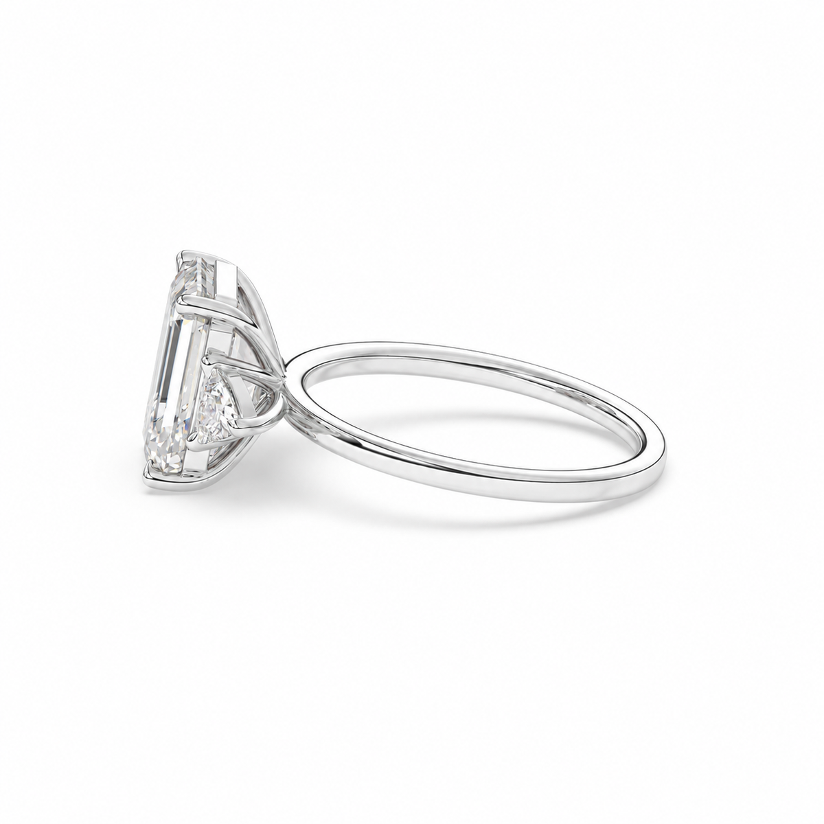 Emerald-cut diamond three-stone ring with trillion diamond shoulders