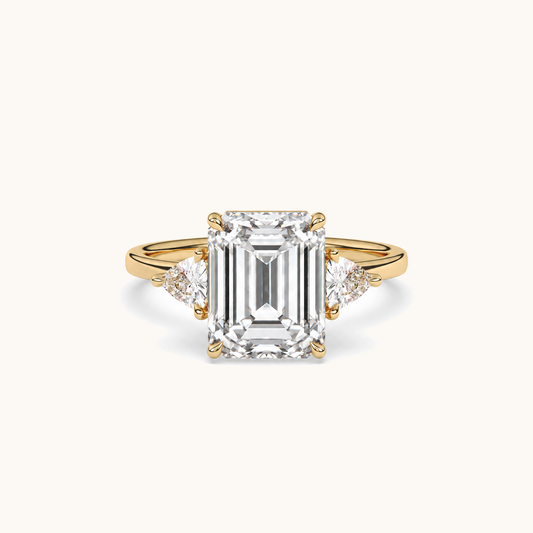 Emerald-cut diamond three-stone ring with trillion diamond shoulders