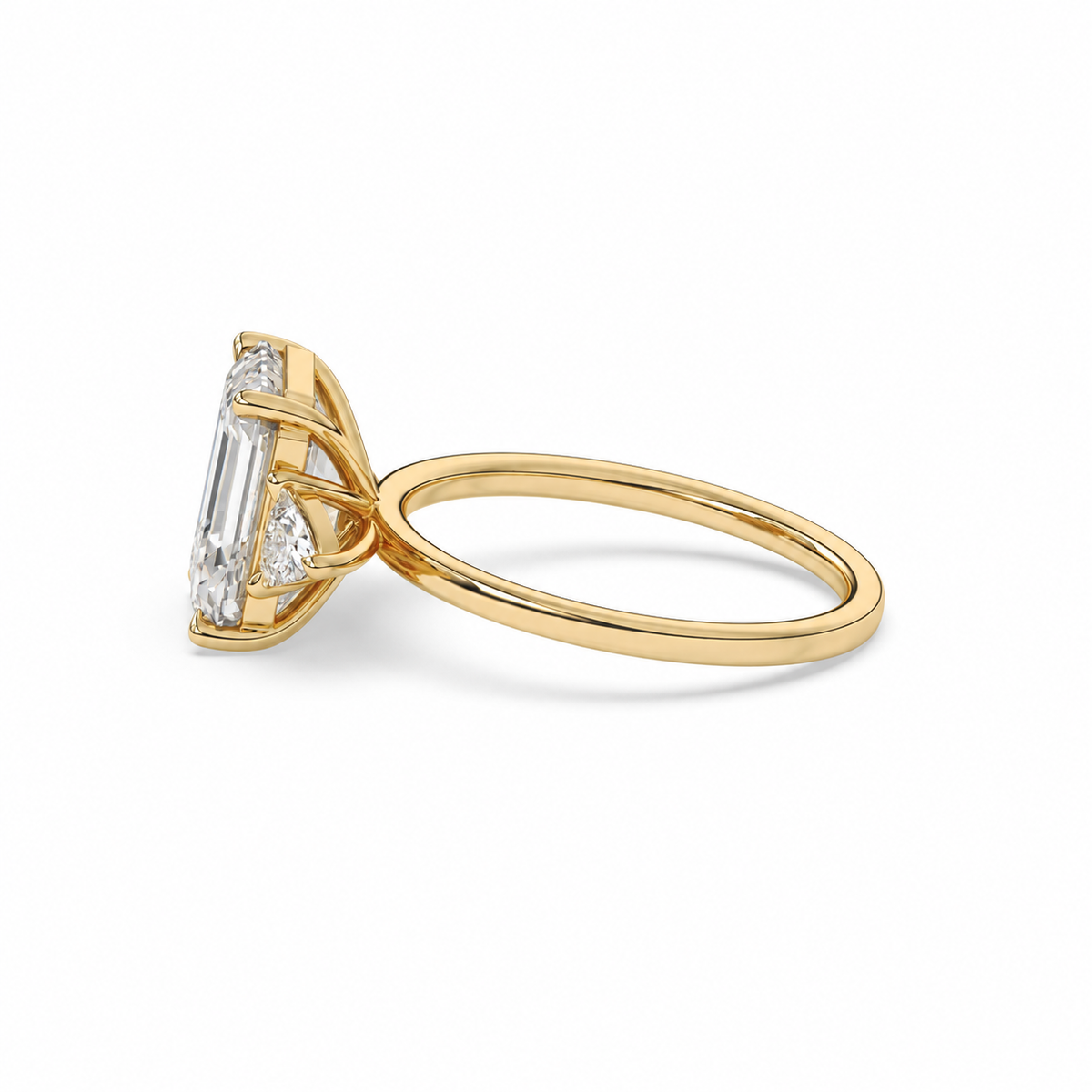 Emerald-cut diamond three-stone ring with trillion diamond shoulders
