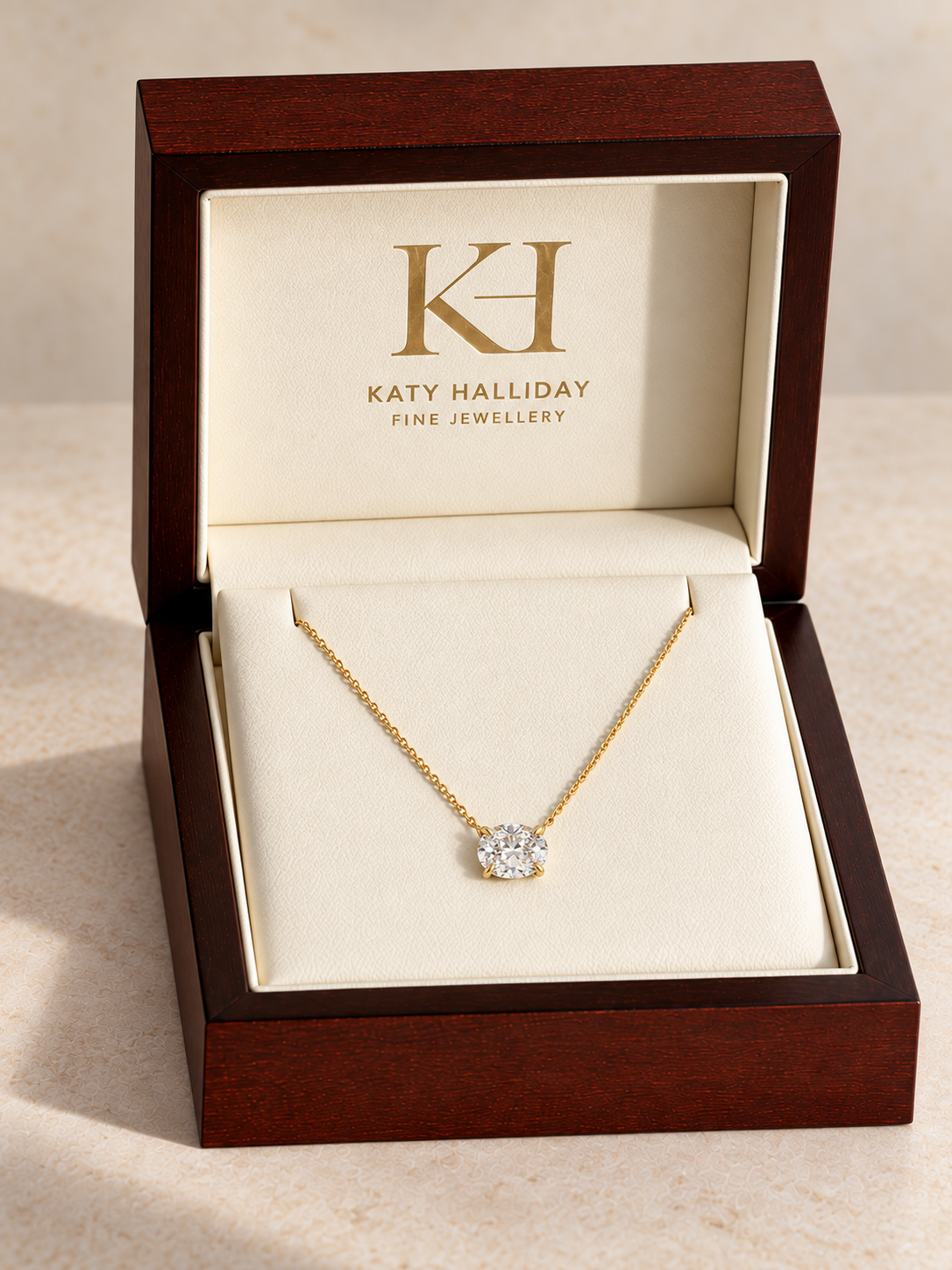 Centred KHFJ wooden necklace presentation box with an oval diamond pendant attached directly to its yellow gold chain