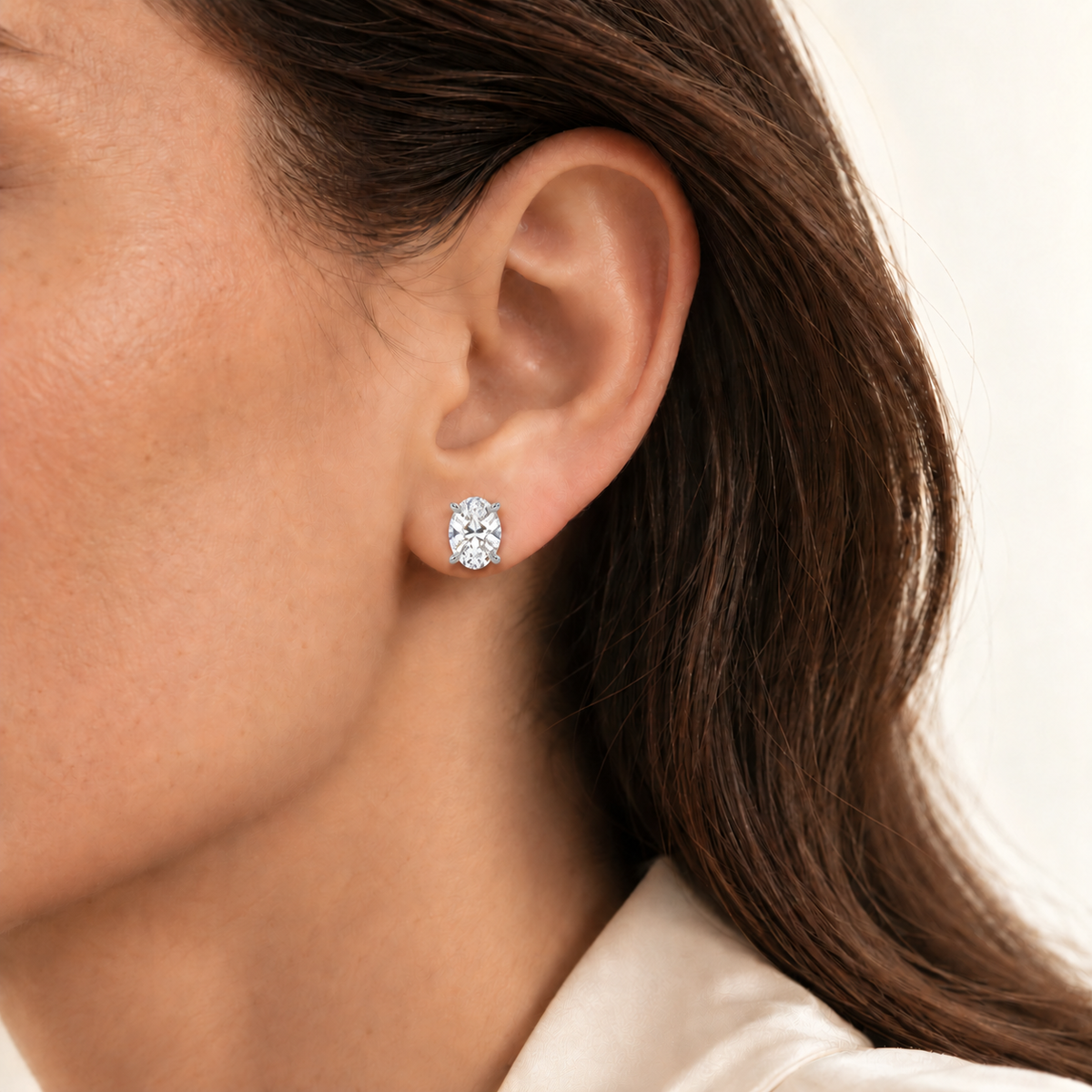 Oval diamond earring on ear, illustrative 2ct total pair, white-metal