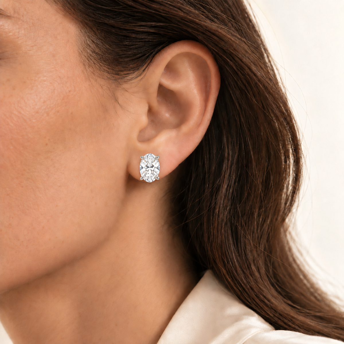 Oval diamond earring on ear, illustrative 4ct total pair, white-metal