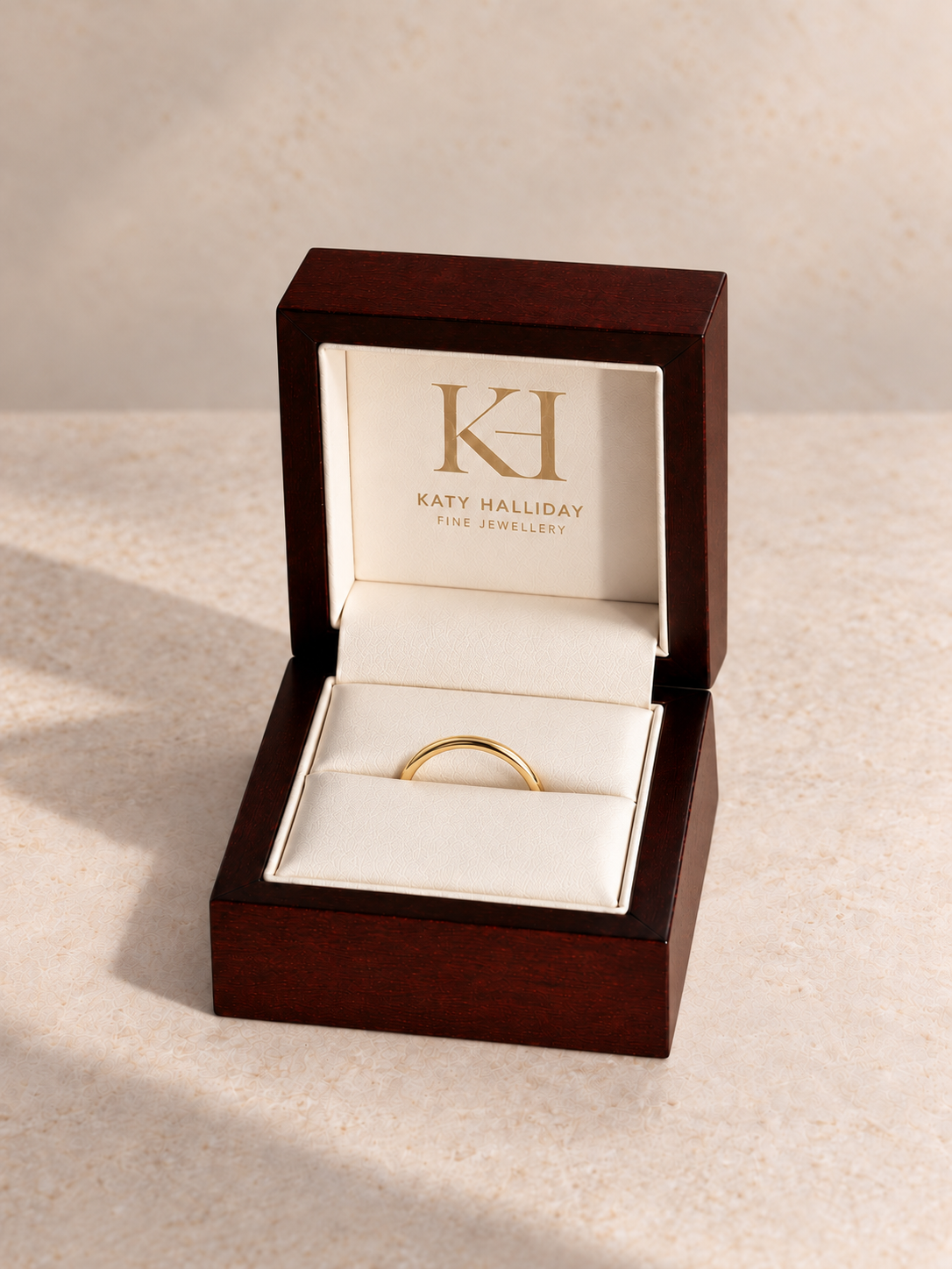 The Signature Band in 18k yellow gold, seated in the angled Katy Halliday wooden presentation box