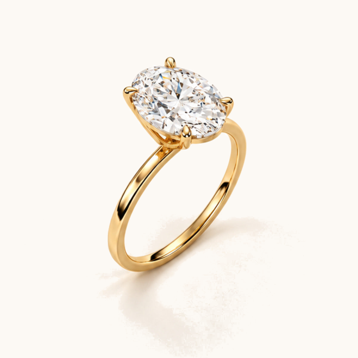 Three-quarter view of the Oval Solitaire in yellow gold, showing its diamond, four claws and fine band