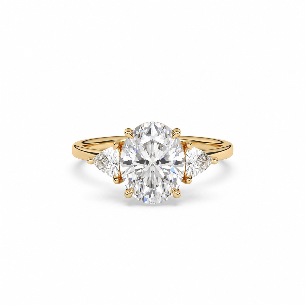 Front view of an oval diamond three-stone ring in yellow gold with trillion diamond shoulders