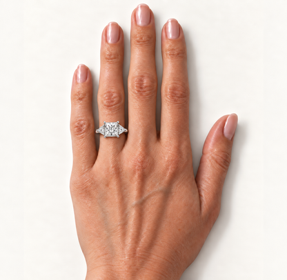 Princess diamond three-stone ring in white metal on the ring finger, high-resolution hand view