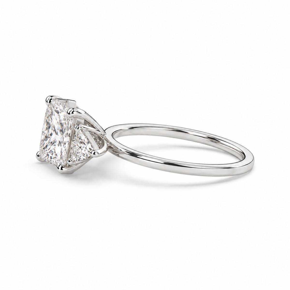 Princess diamond three-stone ring in white metal, low side view