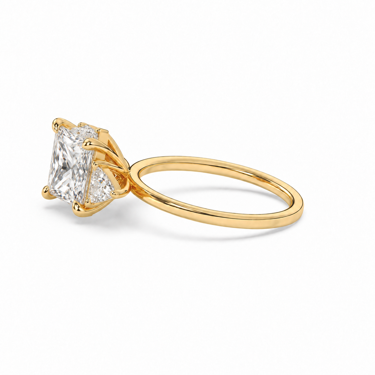 Princess diamond three-stone ring in yellow gold, low side view